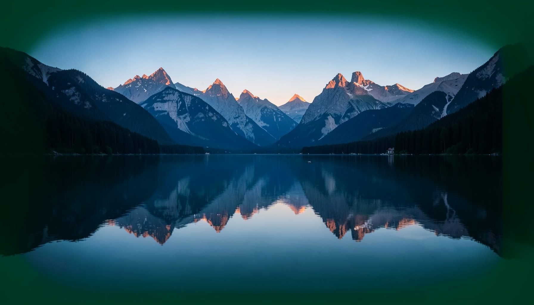 Ruhiger Bergsee in der Abenddämmerung mit gespiegelten Gipfeln, kühle Blau- und Grautöne