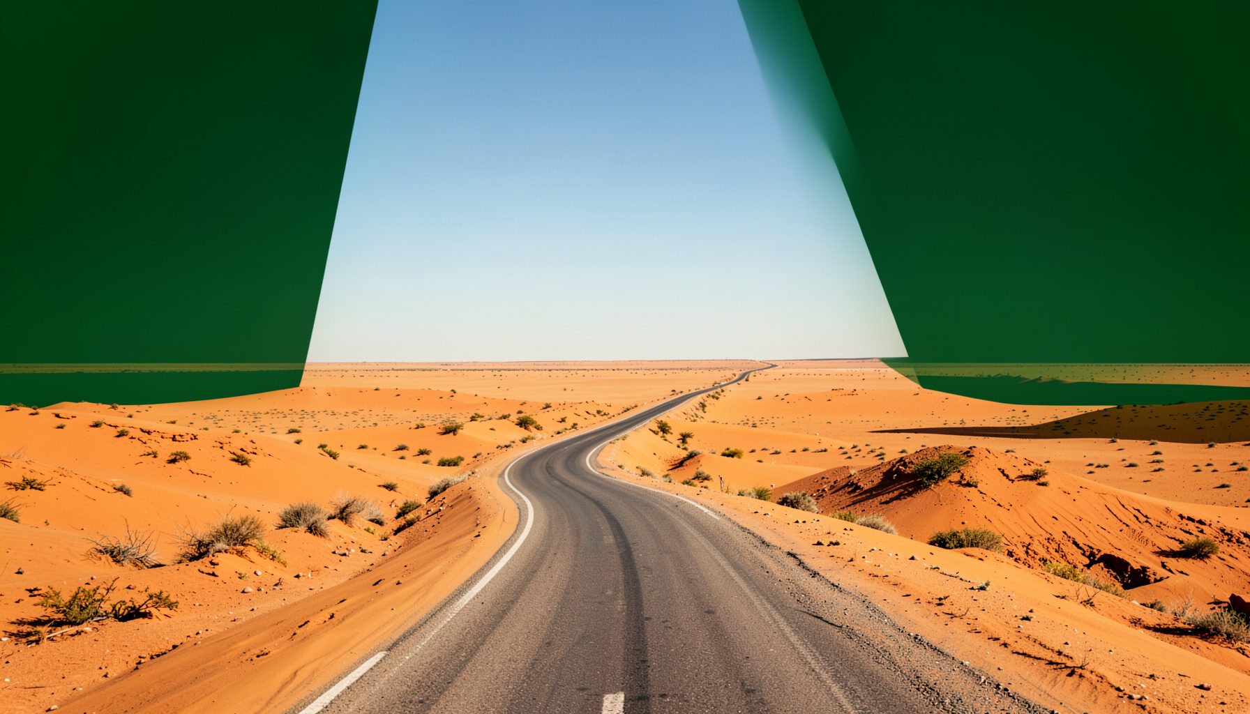 Gewundene Strasse durch eine weite Wüstenlandschaft unter klarem Himmel, warme Sand- und Ockertöne, Gefühl von Freiheit